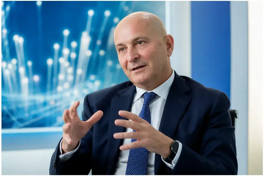 Retrato profissional de Massimo Sarmi, CEO da FiberCop, em escritório corporativo moderno.