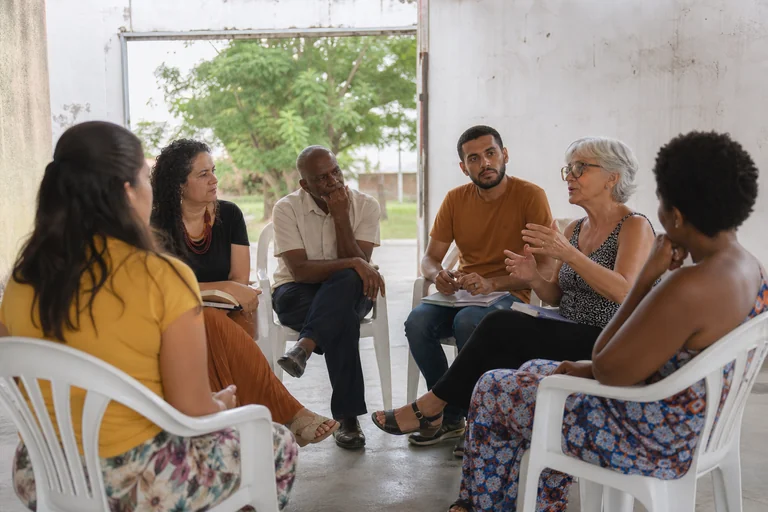 Roda de conversa comunitária em espaço público coberto.