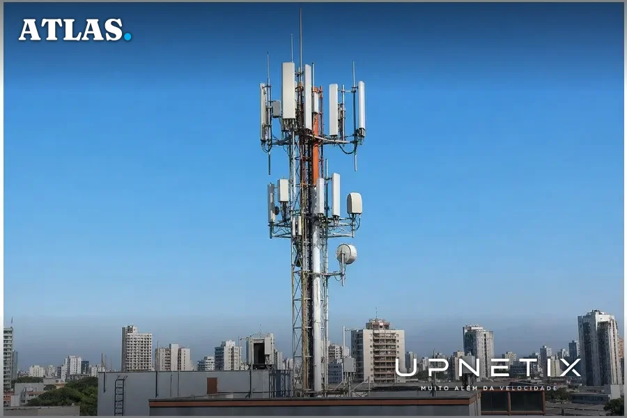Torre de telecomunicações com antenas 2G, 3G e 4G em uma cidade brasileira, simbolizando o compartilhamento de rede entre Vivo e TIM.
