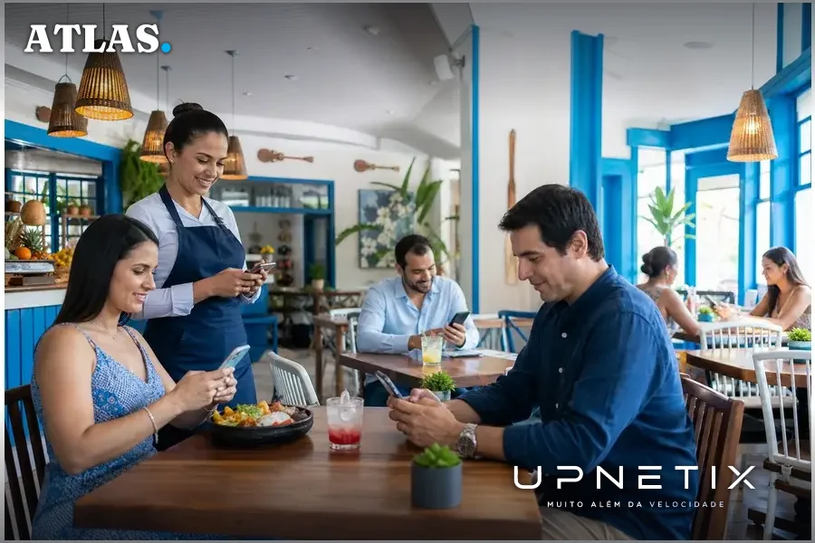 Clientes em restaurante de Manaus usando smartphones conectados ao Wi-Fi gratuito da Upnetix