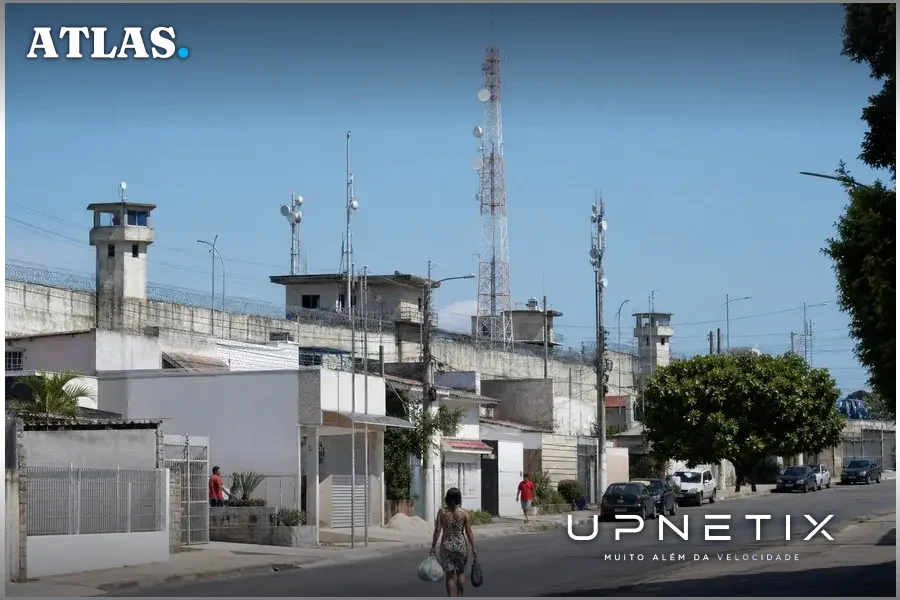 Área residencial próxima a presídio com antenas de telecomunicações, destacando o desafio de evitar interferência dos bloqueios.