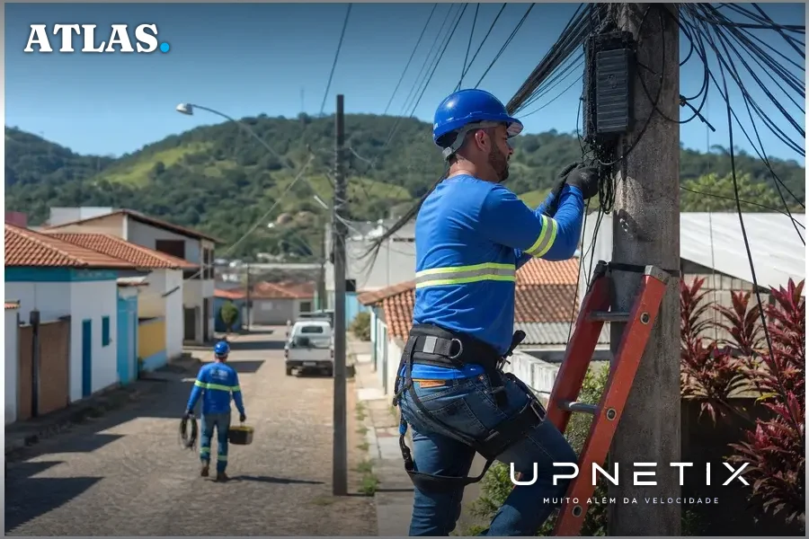 Técnicos instalando equipamentos de fibra óptica em cidade pequena
