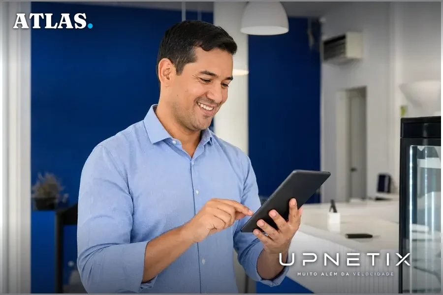Empresário satisfeito usando dispositivo digital, simbolizando o plano Grátis da Upnetix para Wi-Fi em estabelecimentos comerciais
