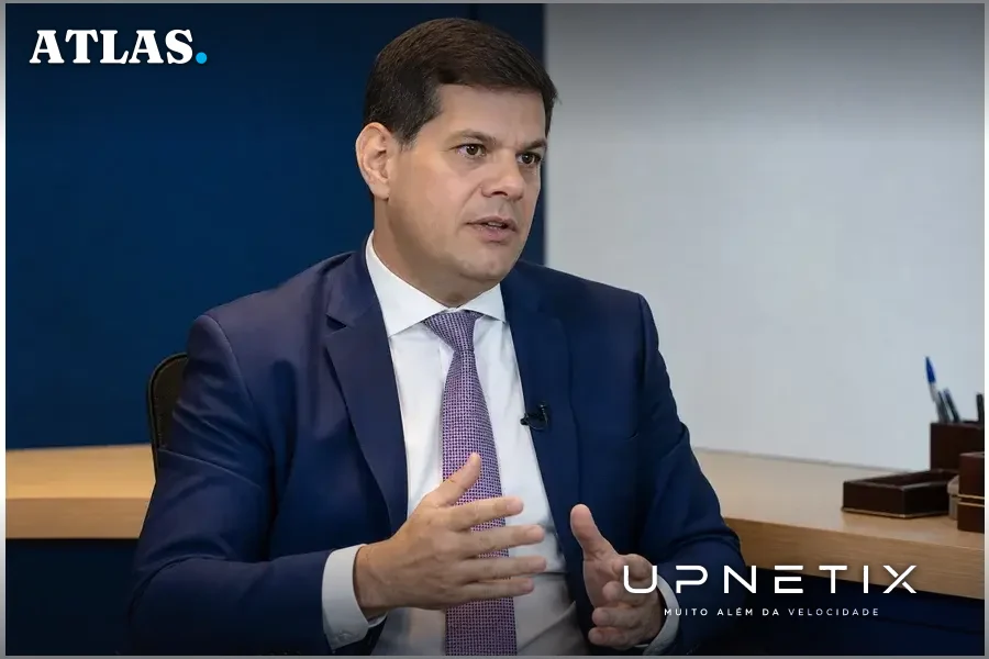 Retrato realista do conselheiro Alexandre Freire durante entrevista em escritório corporativo moderno.