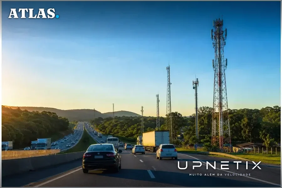 Rodovia federal brasileira com torres de telefonia móvel 4G/5G e tráfego de veículos ao entardecer