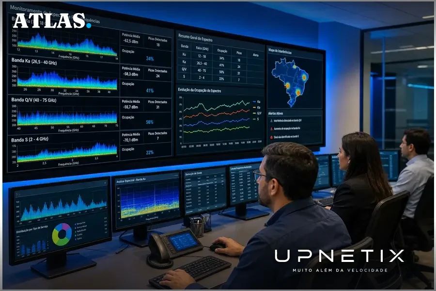 Engenheiros analisando espectro de frequências em sala de operações da Anatel.