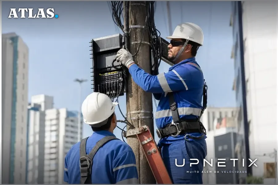 Técnicos da Claro instalando cabos de fibra óptica em poste urbano em São Paulo.