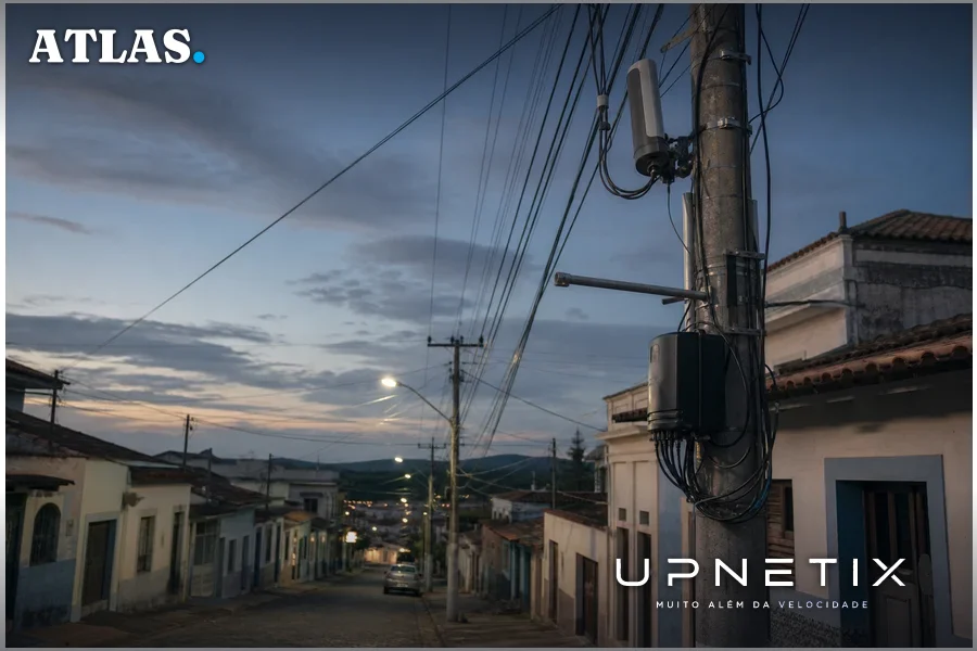 Postes urbanos com cabos e equipamentos de telecomunicações em cidade pequena brasileira ao entardecer