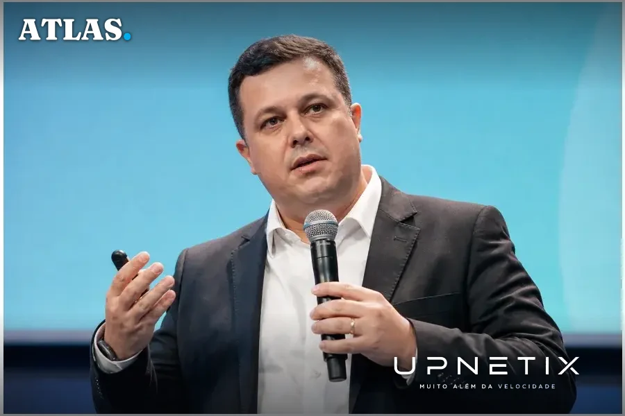Retrato realista de Breno Vale discursando em evento corporativo com fundo neutro azul.